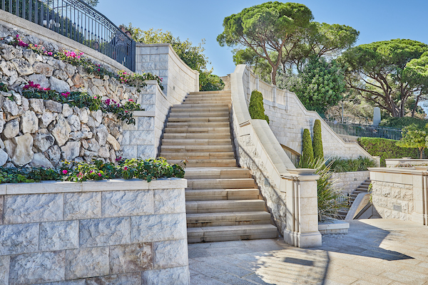Stone staircase with stone walls and greenery against the blue sky. RMS Traders stairs