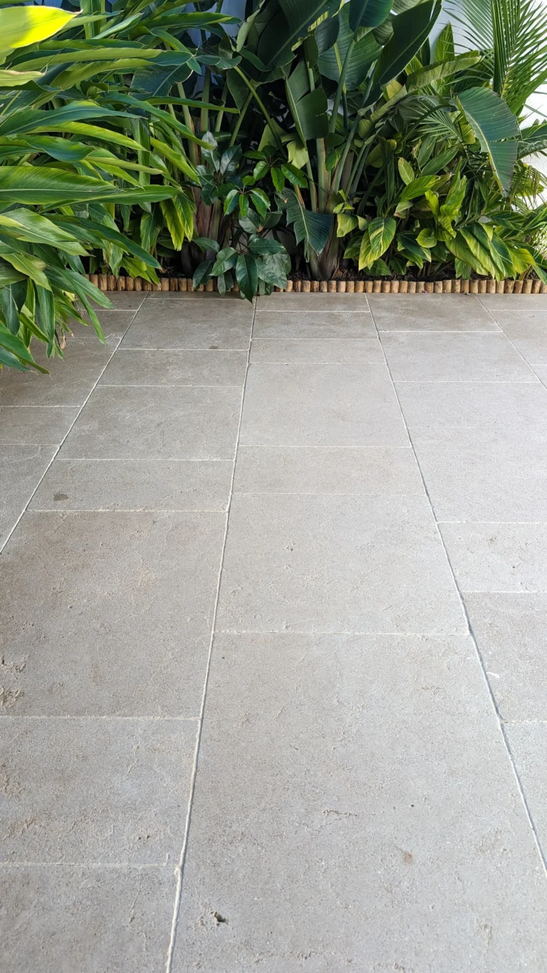 Limestone tiles with lush greenery backdrop by RMS Traders based on Melbourne Australia